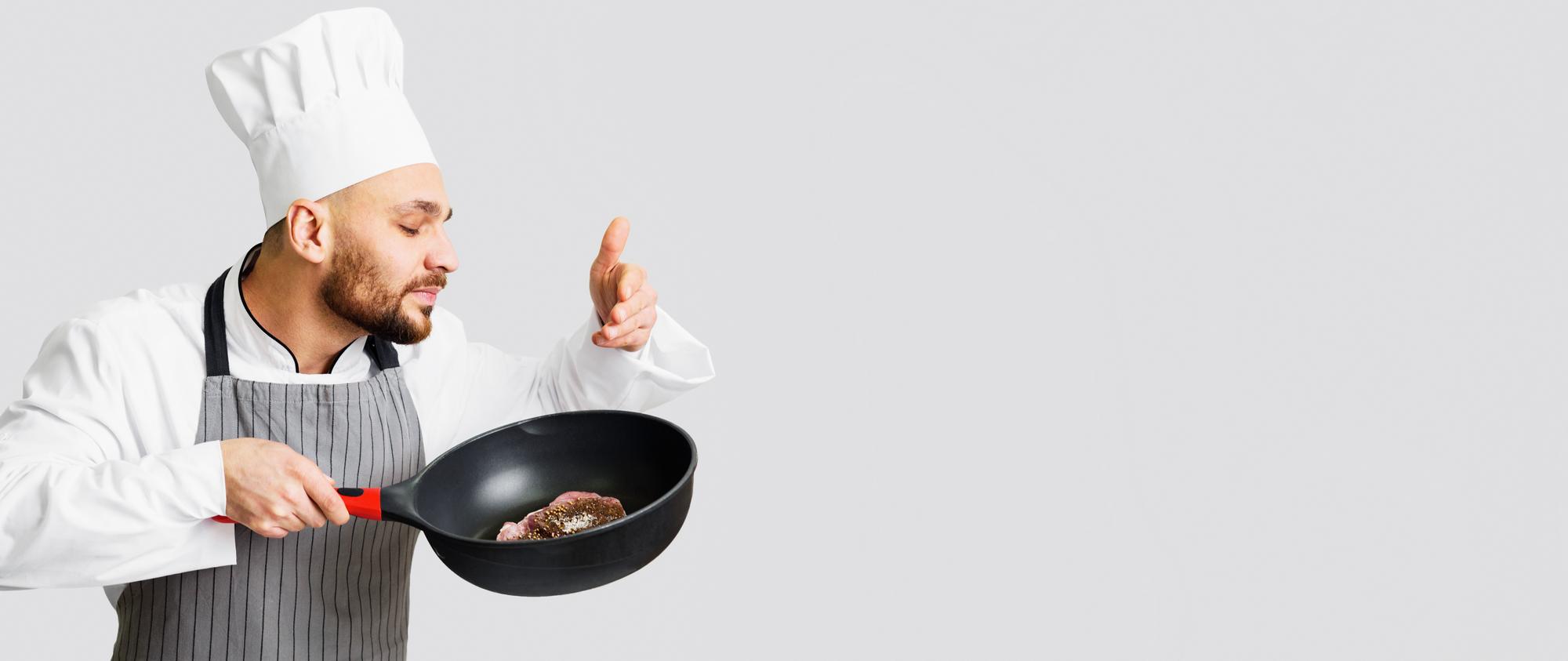 Chef che mostra una tecnica di frittura in cucina moderna